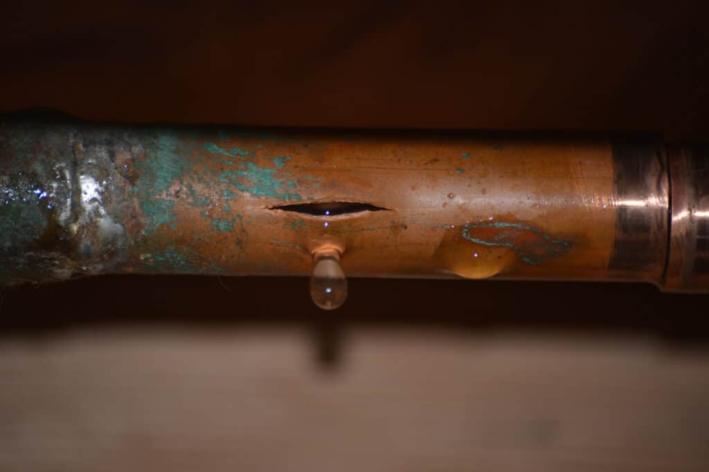 Broken water pipe with water dripping from the crack